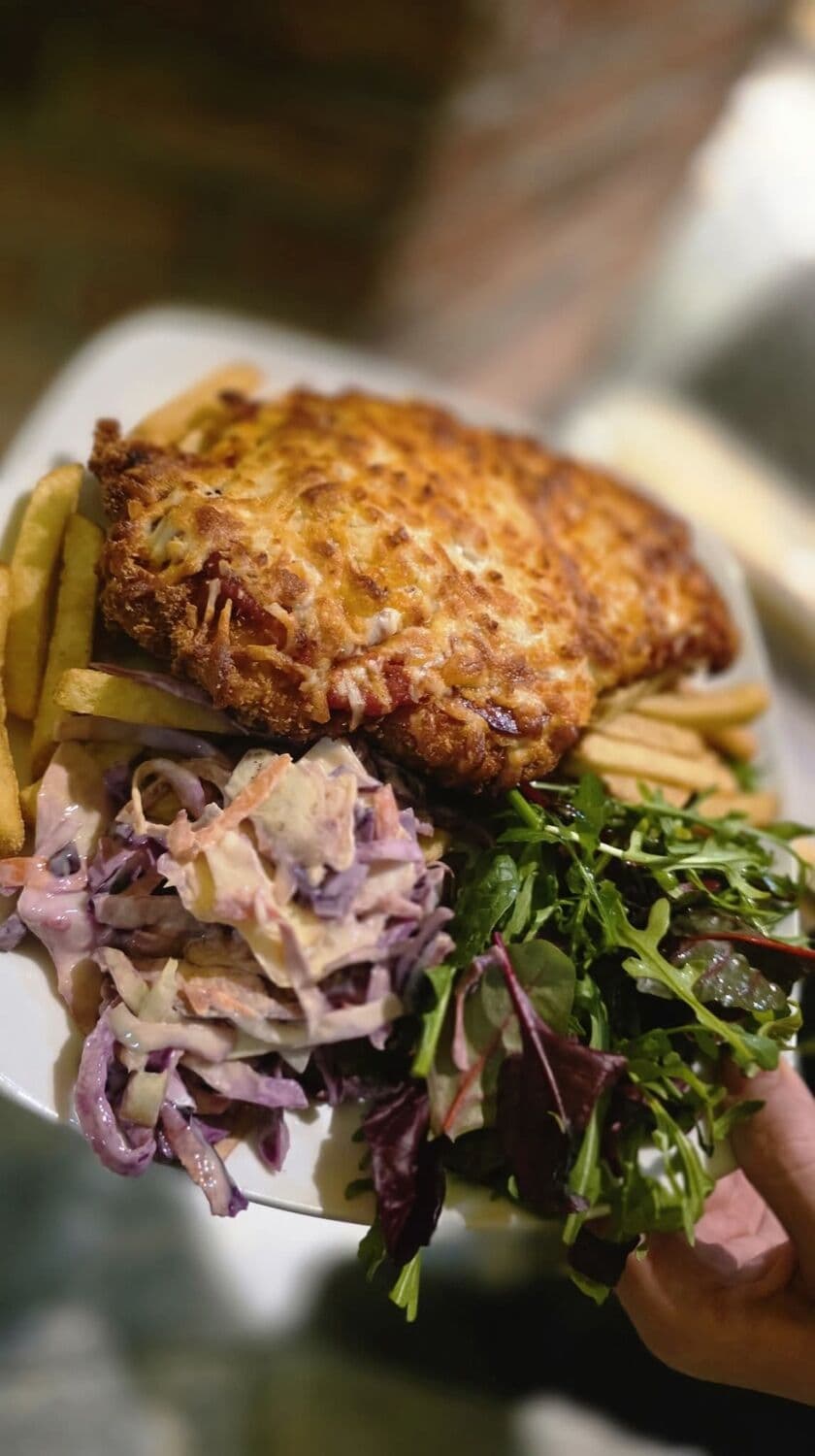 A Lakeside parmo: breaded chicken in béchamel and cheese with chips, coleslaw and salad