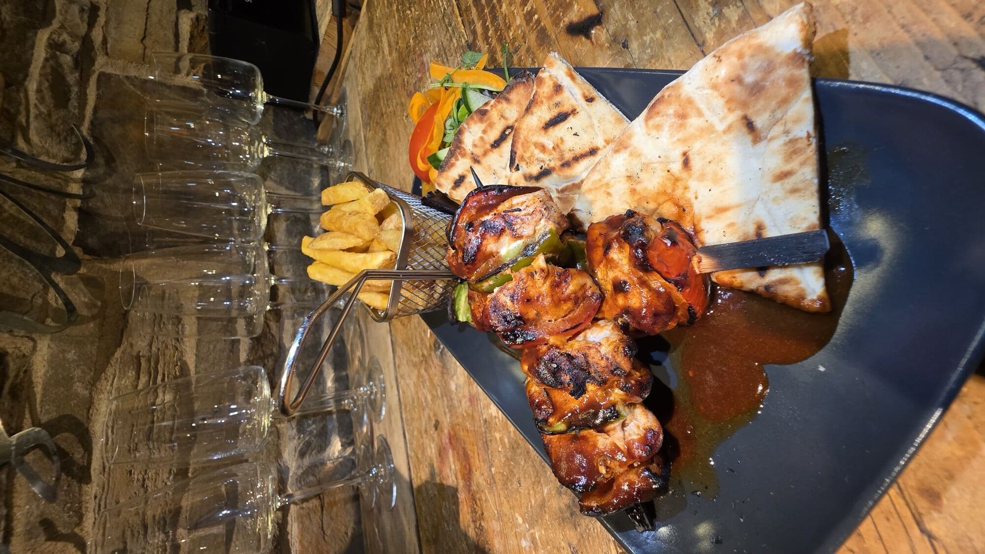 Chargrilled chicken skewers with flatbread and chips at The Lakeside Inn