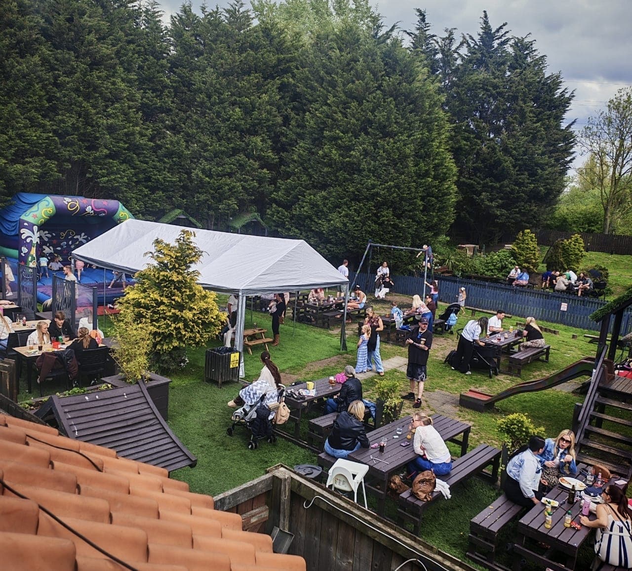 Families in the beer garden with a bouncy castle and play area at The Lakeside