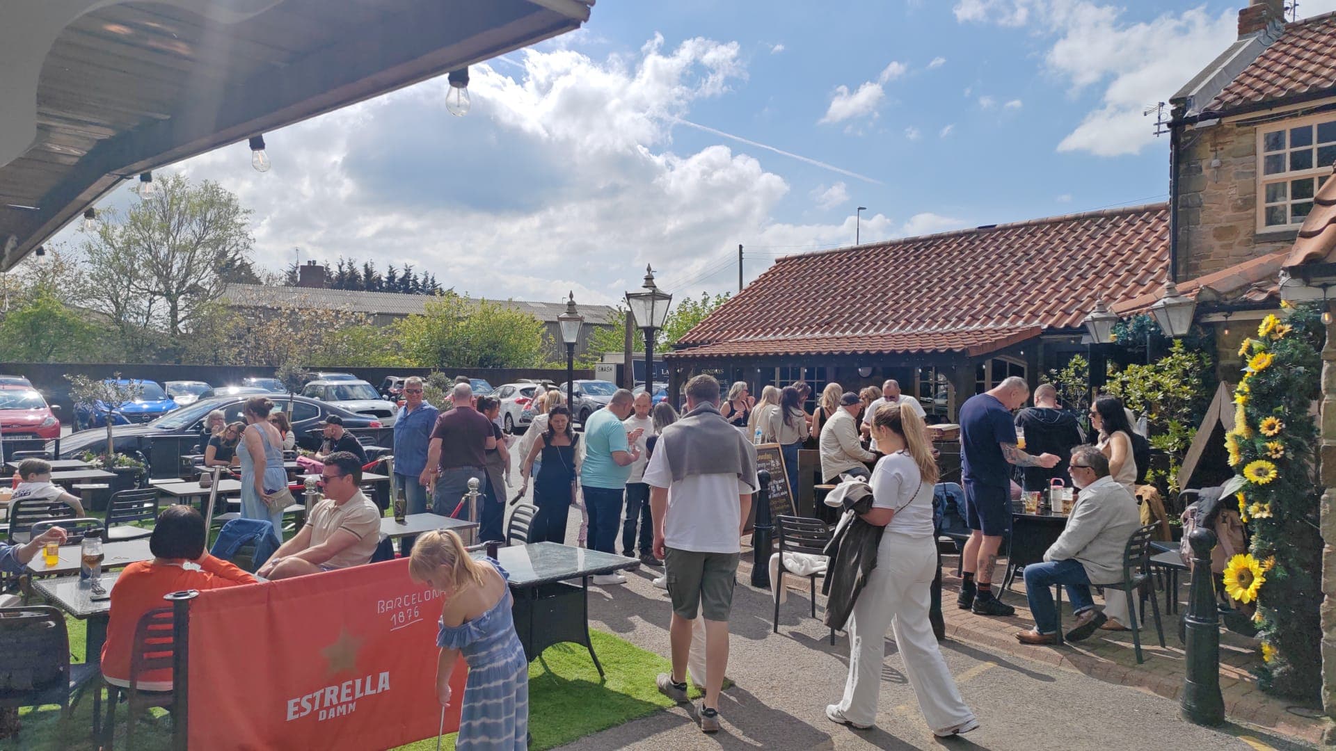 A busy sunny patio packed with guests outside The Lakeside