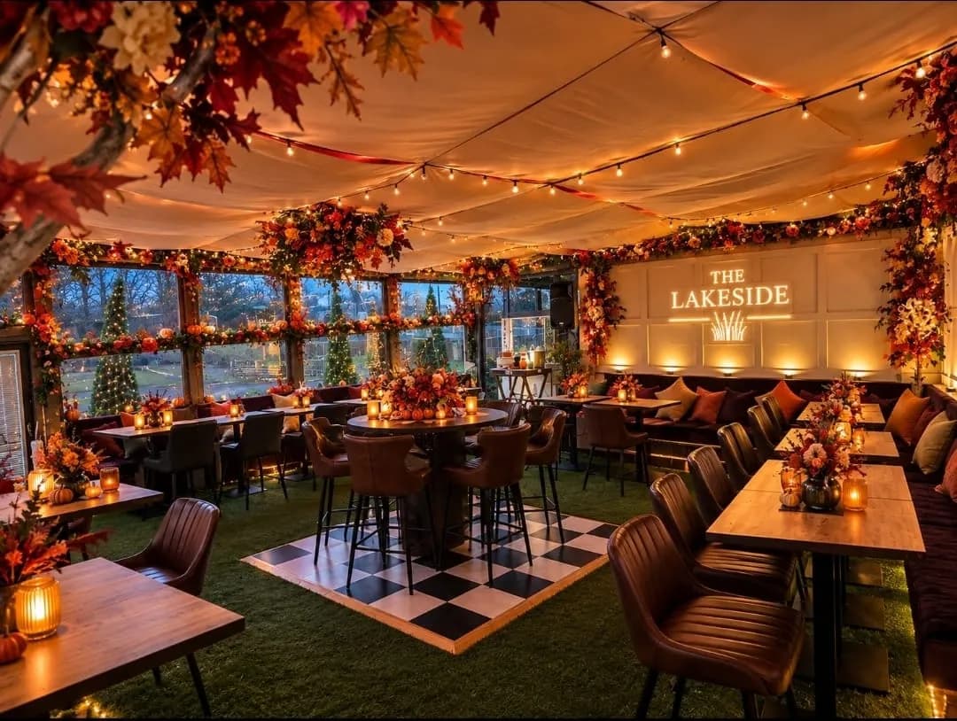 The new Gin Garden at The Lakeside at dusk, dressed in autumn leaves and pumpkins, with candlelit tables, leather chairs and festoon lights